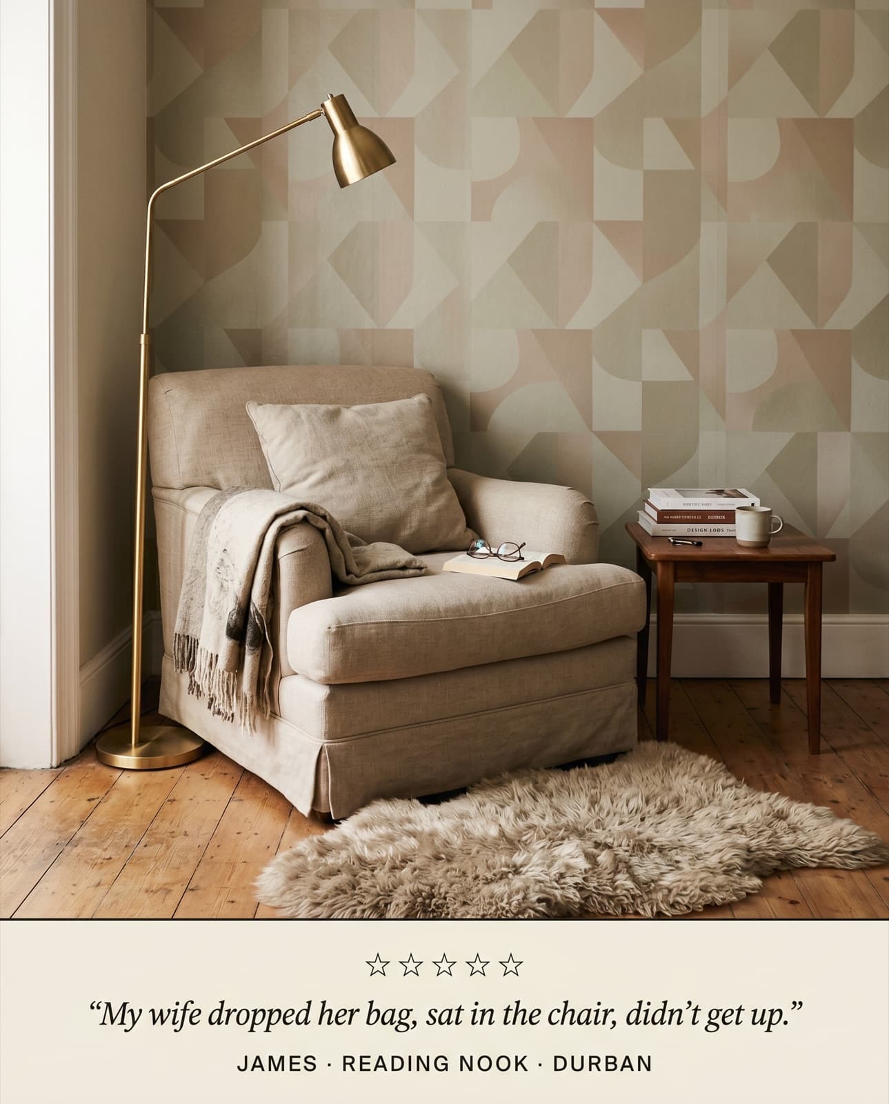 Reading nook with custom geometric wallpaper, oatmeal armchair, brass lamp